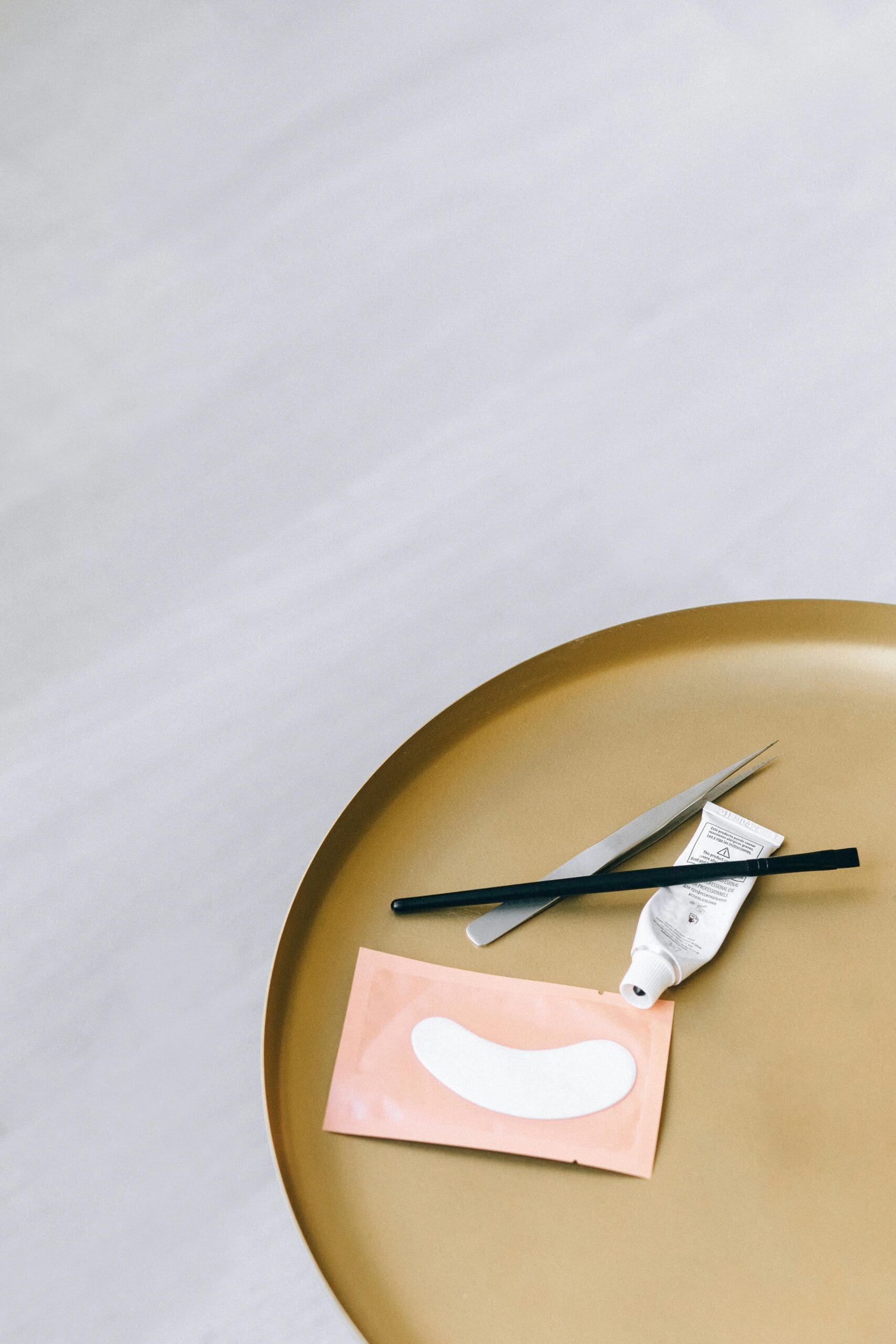 A close-up of essential tools like tweezers and an eye patch, representing the precision of lash and brow services. This image inspires website design ideas that highlight the expertise of lash artists and brow specialists. #lashtools #browtools #websiteforlashartist