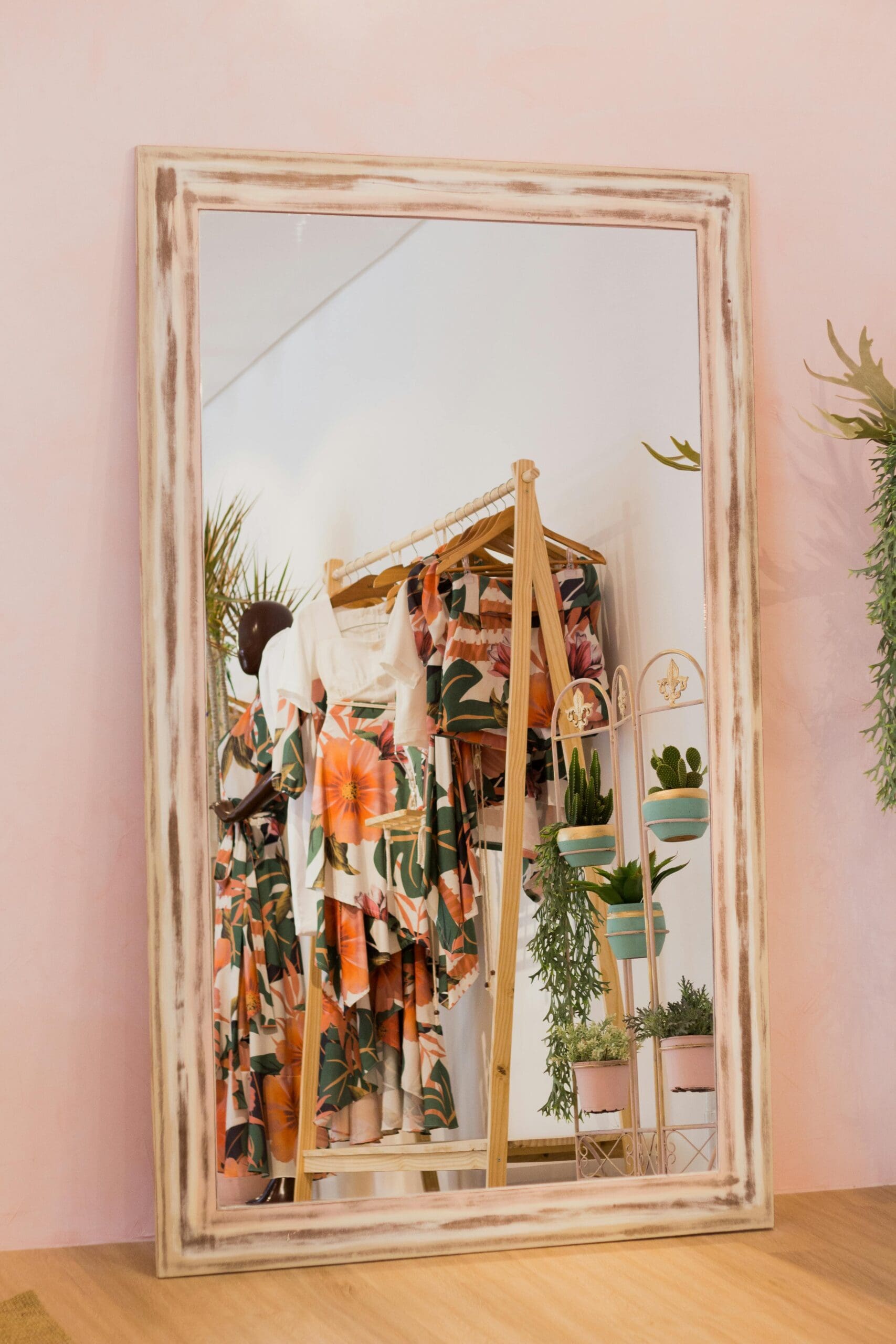 A stylish mirror reflecting a visually appealing clothing rack in a boutique setting. This image emphasizes the importance of creating an attractive aesthetic to draw clients to your online boutique. #onlineboutique #visualmerchandising #aesthetic